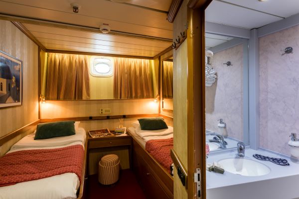 Kabinenkategorie C mit Doppelbett und funktionaler Einrichtung.