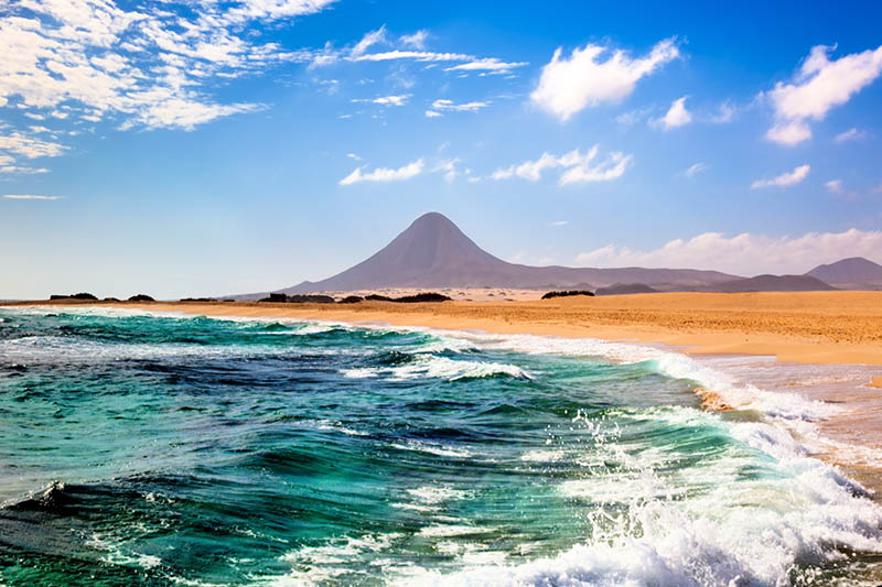 Meeresbucht mit weitläufigem Strand und dem Berg Pico de la Zarza im Hintergrund an einem schönen Sommertag.
