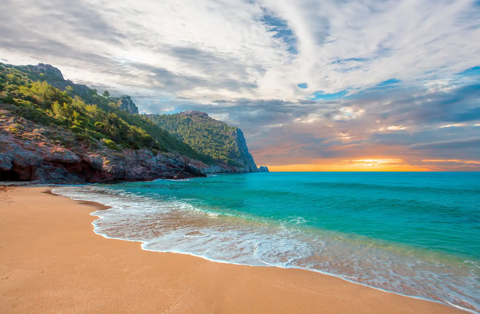 Strand von Kleopatra mit Meer und Felsen bei Sonnenuntergang auf der Halbinsel Alanya.