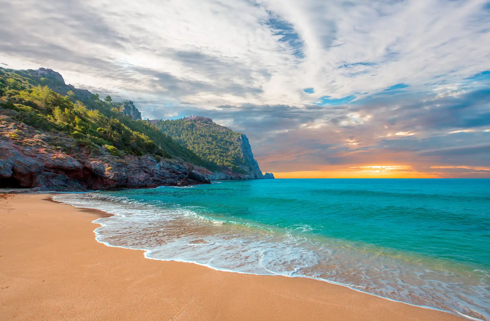 Strand von Kleopatra mit Meer und Felsen bei Sonnenuntergang auf der Halbinsel Alanya.